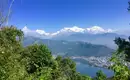 Atemberaubender Blick auf das Annapurna-Massiv Atemberaubende Aussicht auf das Annapurna-Massiv in Nepal mit üppiger Vegetation im Vordergrund und einem klaren blauen Himmel.
