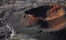 Menschen erkunden einen Krater in vulkanischer Umgebung auf La Réunion.