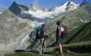 Zwei Wanderer stehen vor einem beeindruckenden Alpenpanorama im Mont Blanc Gebiet.