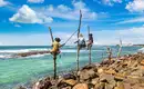 Traditionelles Fischerdorf an Sri Lankas Küste Fischer auf Stelzen am malerischen Strand von Sri Lanka