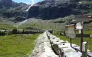 Wandern zur Zufallhütte Steinpfad mit Wegweisern, Bergkulisse und Wasserfall in Südtirol.
