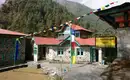 Charmantes Gasthaus im Himalaya Ein traditionelles Gasthaus im Himalaya mit bunten Gebetsfahnen.