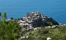 Atemberaubende Aussicht auf Corniglia Blick auf das Küstendorf Corniglia in den Cinque Terre, umgeben von Weinbergen und dem blauen Meer.