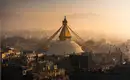 Majestätische Bodnath Stupa bei Sonnenaufgang Sonnenaufgang über der Bodnath Stupa in Kathmandu, Nepal, mit umgebenden Gebäuden.