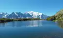 Klarer Bergsee mit schneebedeckten Gipfeln im Hintergrund, Mont Blanc Massiv.