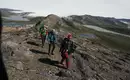 Wanderer auf Grönlands Bergpfaden Drei Wanderer in der arktischen Landschaft Grönlands mit Bergseen und Gletscher im Hintergrund.