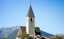 Kirche in idyllischer Berglandschaft Kirchturm in Südtirol vor Alpenpanorama und blauem Himmel.