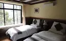 Gemütliches Schlafzimmer in unserer Lodge im Himalaya Zimmer mit zwei Betten und großem Fenster in einer Lodge im Himalaya