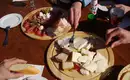 Mhh! So lecker, unserer Brettljause... Wanderer genießen eine Almjause mit Käse und Aufschnitt.