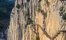 Schmaler Wanderweg Caminito del Rey entlang steiler Felswand in Spanien.