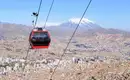 Seilbahn über La Paz mit Bergen Rote Seilbahn fährt über das Stadtbild von La Paz mit Bergen im Hintergrund.