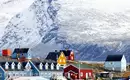 Bunte Häuser in der Arktis Bunte Häuser in Grönland vor schneebedeckten Bergen. Eine malerische Szenerie in der Arktis.