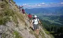 Vom Steineberg geht es über einen gut gesicherten Weg Richtung Stuiben, im Hintergrund erkennt man Sonthofen Wandergruppe am steilen Abhang im Naturpark Nagelfluhkette mit Alpenblick.