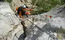Jede Menge Trittstifte erwarten uns! Kletterer auf einem Klettersteig mit Stahlseil und Leitern in felsigem Gelände.