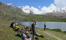 Wohlverdiente Mittagspause am Stellisee Wanderer entspannen sich am Ufer eines Bergsees mit Alpenblick.