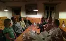 Gemütliches Beisammensein in der Hütte Gruppe von Menschen in gemütlicher Berghütte bei Abendessen.