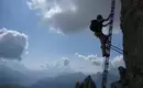 Himmelsleiter in den Dolomiten Person auf Klettersteig mit Bergpanorama und bewölktem Himmel auf langer Leiter