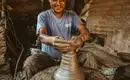 Töpferkunst in Nepals Dörfern Ein lächelnder Mann töpfert in einer traditionellen Werkstatt in Nepal.