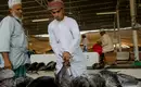 Marktszene auf dem Fischmarkt in Oman Ein Mann in traditioneller Kleidung begutachtet frischen Fisch auf einem Markt in Oman.