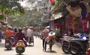 Straßenszene in Hanoi, Vietnam Menschen auf Fahrrädern und Mopeds in einer belebten Straße in Hanoi, Vietnam.