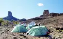 Trekking im Saghro-Gebirge Gruppe von Zelten in der felsigen Landschaft des Saghro-Gebirges mit Felsformationen im Hintergrund.