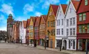 Historische Holzhäuser in Bergen Historische Holzhäuser in Bergen, Norwegen, blaue Himmel, Kopfsteinpflasterstraße.