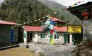 Charmantes Gasthaus im Himalaya Ein traditionelles Gasthaus im Himalaya mit bunten Gebetsfahnen.