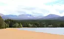 Strand im Cairngorms National Park Sandstrand mit Wald und Bergen im Cairngorms National Park, Schottland.