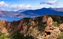 Panorama der Calanche di Piana Eine kurvenreiche Straße führt durch rote Felsen mit einem Ausblick auf das blaue Meer und die Berglandschaft in der Calanche di Piana.