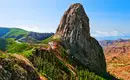 Spektakuläre Aussicht auf den Roque Agando von La Gomera Blick auf den imposanten Roque Agando auf La Gomera, umgeben von grüner Vegetation und blauem Himmel.