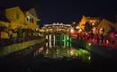 Nachtansicht von Hoi An mit beleuchteter Brücke Stimmungsvolle Beleuchtung und Menschen an einer Brücke in Hoi An bei Nacht.