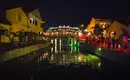 Nachtansicht von Hoi An mit beleuchteter Brücke Stimmungsvolle Beleuchtung und Menschen an einer Brücke in Hoi An bei Nacht.