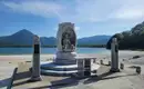 Buddhistische Schreine begleiten und entlang unserer Wege Skulptur am See mit Bergen im Hintergrund, blauer Himmel