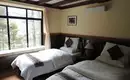 Gemütliches Schlafzimmer in unserer Lodge im Himalaya Zimmer mit zwei Betten und großem Fenster in einer Lodge im Himalaya