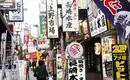 Belebte japanische Einkaufsstraße Bunte Schilder und Menschen auf einer geschäftigen Straße in Japan.
