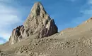 Trekking im Hoggar-Gebirge, Algerien Imposanter Felsen im Hoggar-Gebirge unter klarem Himmel.