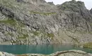 Abenteuerliche Wanderung in den Schweizer Alpen Steiniger Bergsee umgeben von felsigen Alpen, perfekte Kulisse für Wanderungen.