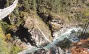 Hängebrücke im Himalaya Hängebrücke über einem Fluss, umgeben von Bergen.