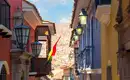 Bunte Gasse in La Paz, Bolivien Schmale Straße in La Paz mit bunten Gebäuden und bolivianischer Fahne.
