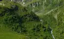 Alpine Landschaft mit Wasserfall Berglandschaft in den Schladminger Tauern mit Wasserfall und grüner Vegetation.