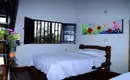 Eines unserer Zimmer in Kolumbien Rustikales Zimmer mit Doppelbett, Fenster und bunter Wanddekoration.