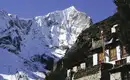Everest Komfort Trek: Bergpanorama Verschneite Berge in Nepal, traditionelles Haus im Vordergrund.