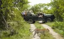 Safari-Abenteuer im Krüger-Nationalpark Gruppe auf Safari im Jeep beobachtet einen Leoparden im Krüger-Nationalpark.