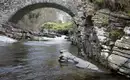 Tolle Steinbrücke über einen Fluss in den Highlands Natursteinbrücke über einen ruhigen Fluss in den schottischen Highlands.