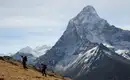 Trekking in Nepals Himalaya-Bergwelt Zwei Wanderer vor einer beeindruckenden, schneebedeckten Bergkulisse in Nepal.