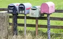 Ländliche Briefkästen: Sie haben Post!;-) Vier bunt gefärbte Briefkästen auf einer ländlichen Straße in Neuseeland.
