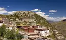 Eines der vielen Klöster, die unseren Weg säumen Historisches Kloster in der tibetischen Hochebene mit Bergen im Hintergrund