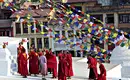 Bunte Gebetsfahnen am Stupa in Nepal Mönche in roten Roben vor einem Stupa mit bunten Gebetsfahnen in Nepal.