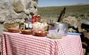Outdoor Picknick in Chile Tisch mit Picknickutensilien und Essen in chilenischer Landschaft, im Freien.