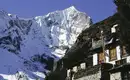 Everest Komfort Trek: Bergpanorama Verschneite Berge in Nepal, traditionelles Haus im Vordergrund.